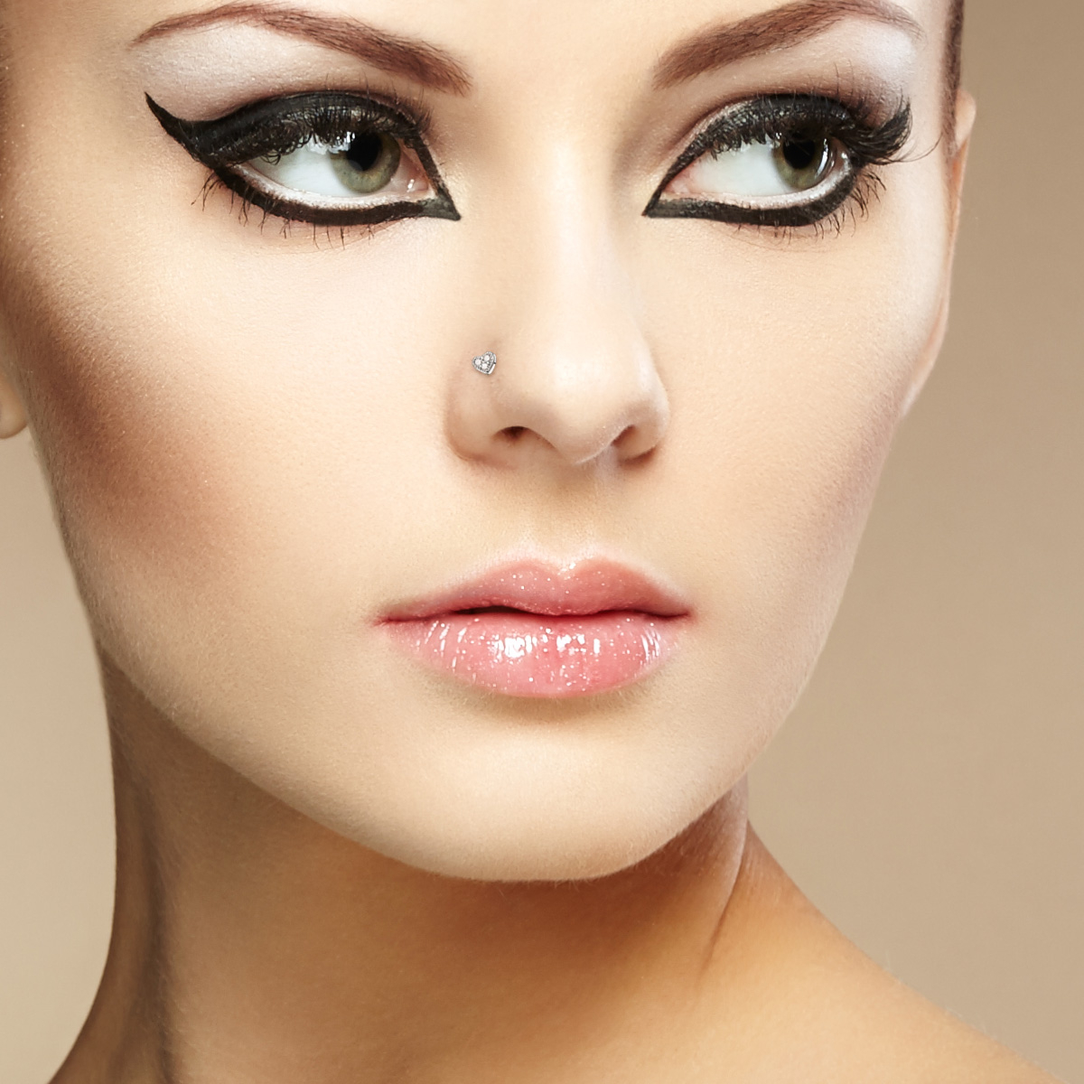 Piercing pour le nez avec un coeur incrusté de trois pierres